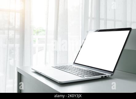 Computer laptop with blank screen on white table in home interior or office background Stock Photo