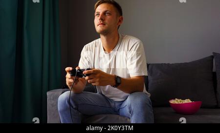 Excited young handsome man playing video game  Stock Photo