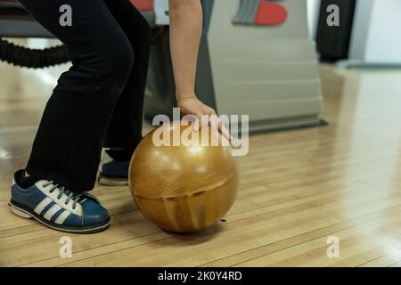 Young girl having fun with ball in bowling club. Stock Photo