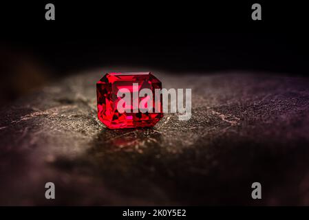 Red Brilliant. Luxury Precious Red Gemstone on Dark Natural Stone Stock Photo