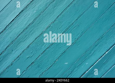 Wide view of old boards at an angle painted green fading from sunlight and weather. Stock Photo