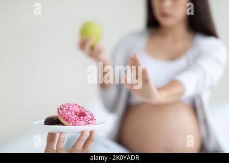 Unrecognizable pregnant woman saying no to unhealthy food Stock Photo