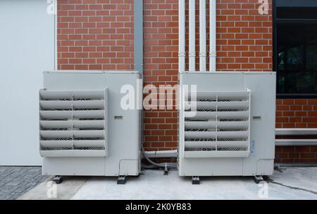 Air compressor or condenser unit installed outside building. Outdoor split air conditioner of the office Stock Photo