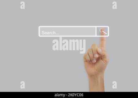 Hand touching magnifying glass icon search page on touch screen with copy space. Concept of searching browsing internet data information networking. Stock Photo