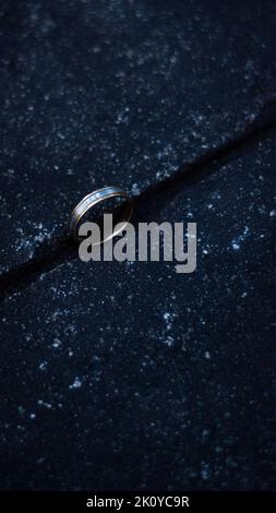 A selective focused picture of a gold and platinum diamond ring in a black background Stock Photo