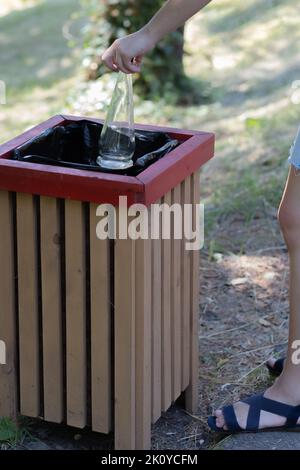 In the hands of two empty glass bottles with a bucket. Ejection of container glass Stock Photo