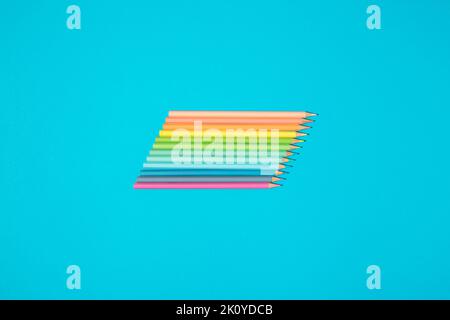 Rainbow palette coloring crayons on blue background. Art and school supply. Stock Photo