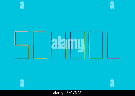 Word school written / made with crayons on blue background. Minimal concept. Stock Photo