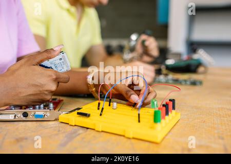 Close up female student hands creating electronic circuits and robotics at class Stock Photo