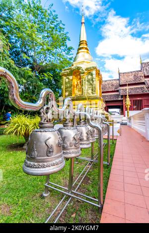 Bells in Wat Phra Singh temple, near the Chiang Mai city, Thailand. Symbol of hope and spirituality. Golden pagoda with ancient temple near. Famous to Stock Photo
