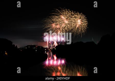 Fireworks above the river canal Roeselare-leie.  Reflections in water of fireworks in flanders Izegem.  Commercial firework photos from in Belgium Stock Photo