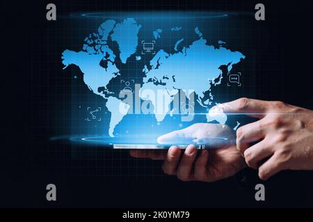 Globalization and the global network of the Internet with a world map and icons like a hologram on a tablet in hands. Stock Photo
