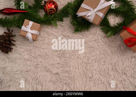 Christmas gift box and fir tree branch on white fur carpet. Flat lay, top view and copy space for text Stock Photo