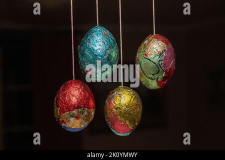 Mixed colored foil wrapped Easter Eggs, hangin on strings. photo: Bo Arrhed Stock Photo
