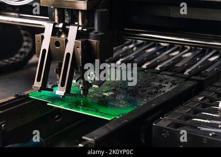 Close-up shot of SMD surface-mount device working on printed circuit board PCB. Assembling electrical components. Precision technology. Horizontal. High quality photo Stock Photo