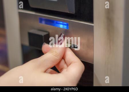 Close-up of human hand inserting coin in vending machine Stock Photo ...