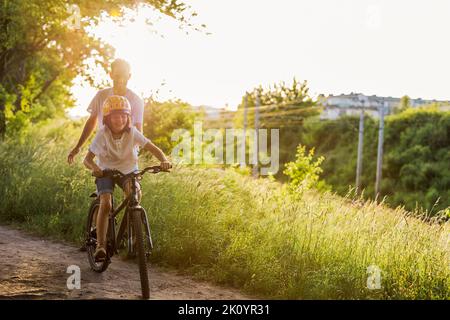 Father teaching his son how to ride a bicycle Stock Photo