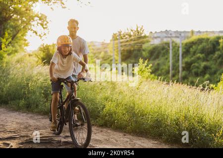 Father teaching his son how to ride a bicycle Stock Photo
