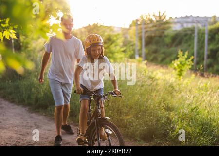 Father teaching his son how to ride a bicycle Stock Photo