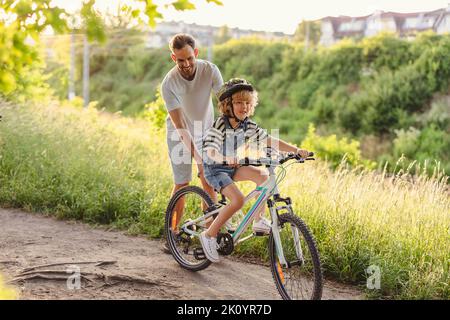 Father teaching his son how to ride a bicycle Stock Photo