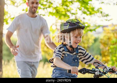 Father teaching his son how to ride a bicycle Stock Photo