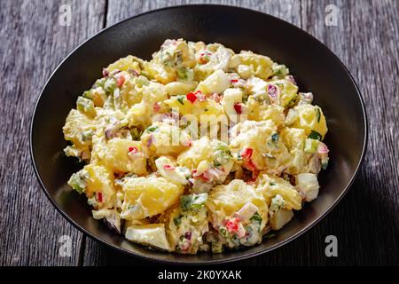delicious shout hallelujah potato salad with pickles, celery, eggs, jalapeno and mayonnaise dressing in black bowl, american cuisine, close-up Stock Photo
