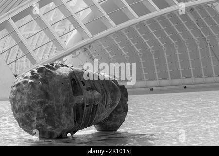 Face head sculpture by Igor Mitoraj in front of Hemisfèric building detail at City of Arts and Sciences in Valencia, Spain in September - monochrome Stock Photo