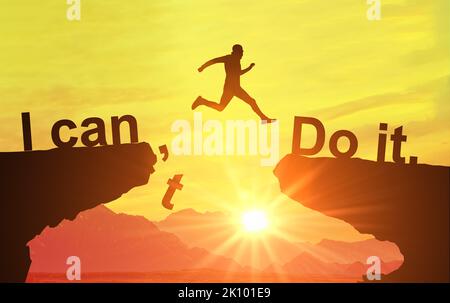 Silhouette man jumping over cliffs for I can do it , good mindset by never give up concept. Motivational image, nothing is impossible. I can do it con Stock Photo