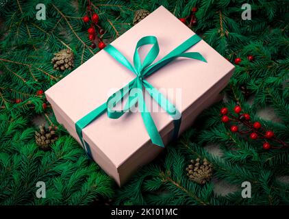 Christmas gift fir. Gift box and Christmas decorations. Christmas composition. Frame made of christmas gifts, dark pine branches on white background. Stock Photo