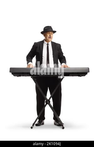 Mature man in a suit and tie playing a digital piano and singing isolated on white background Stock Photo