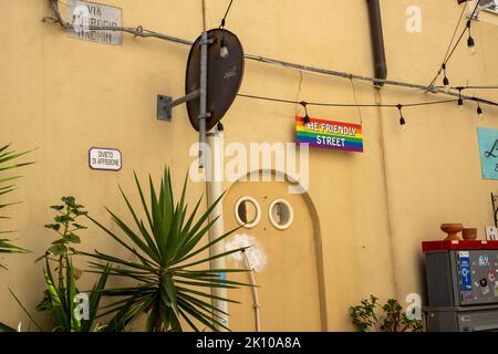 Street name sign of Via Ambrogio Machin dubbed a (gay) friendly street in the old town centre of Alghero, Sardinia, Italy Stock Photo