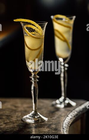two french 75 champagne cocktails with lemon twist garnish in flute glasses Stock Photo