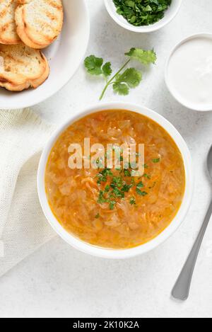 Cabbage (sauerkraut) soup or kislye shchi. White stone background, top view, flat lay Stock Photo