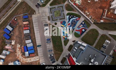 Construction containers and cabins at the construction site. Next to completed yard area. Shot from above, camera down. Aerial photography. Stock Photo