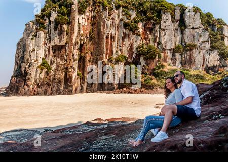 Pregnant couple in love dancing at sunset on the platform of Praia dos Molhes in Torres in Rio Grande do Sul. Stock Photo
