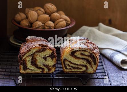 Traditional Easter bread with chocolate and nut filling on a wooden background. Stock Photo