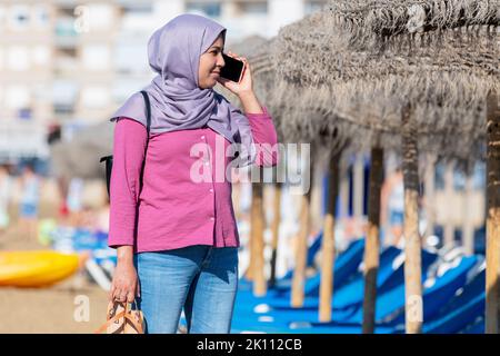Serious looking muslim woman talking on her phone Stock Photo