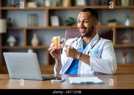 Friendly black doctor working online, having video chat with patient Stock Photo