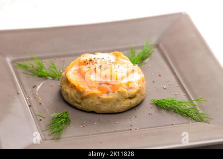 salty cake filled with cream cheese served with smoked salmon and dill Stock Photo