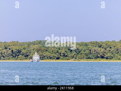 Large motor yacht sitting in Smith Cove with a nature preserve in the background Stock Photo