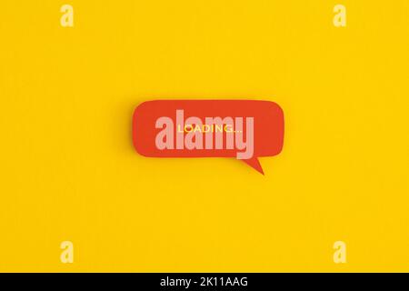 Paper speech bubble with the word 'Loading' on a yellow background. Top view with copy space. Flat lay. Stock Photo