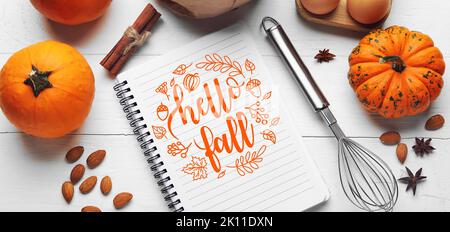 Notebook and ingredients for pumpkin pie on white wooden background, top view Stock Photo