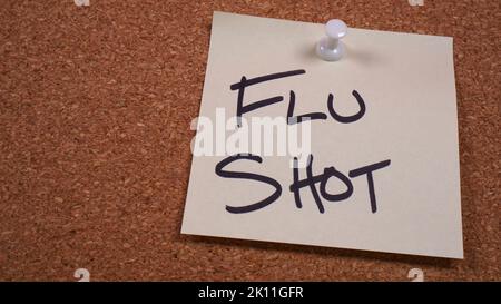 Sticky note reminder on a cork board to get a flu shot Stock Photo