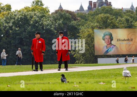 London, UK. 14th Sep, 2022. As crowds of people came to London to watch Her Majesty the Queen's coffin being transported to the Palace of Westminster, two Chelsea Pensioners are pictured in Hyde Park walking in front of the large video screen ahead of the live screening of the procession Of The Queen's Coffin. Credit: Lynchpics/Alamy Live News Stock Photo