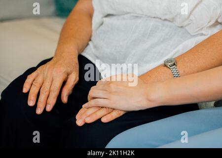 Close up of hands holding between two generations of women. Mother and daughter holding hands. Stock Photo