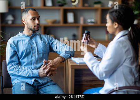 African american doctor showing black guy patient drugs Stock Photo