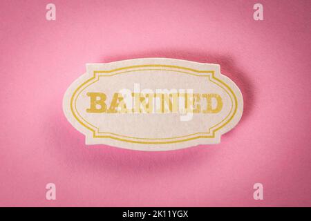 BANNED. Note sticker with text on pink background. Stock Photo