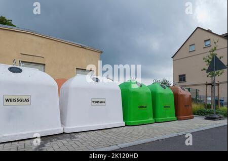 Containers for waste separation by color with the German labels , white glass , green glass and brown glass. Stock Photo