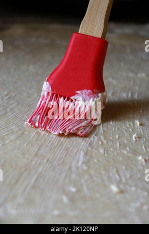 close up of raw dough being brushed with butter Stock Photo