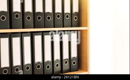 Black office folders standing on cabinet shelves Stock Photo